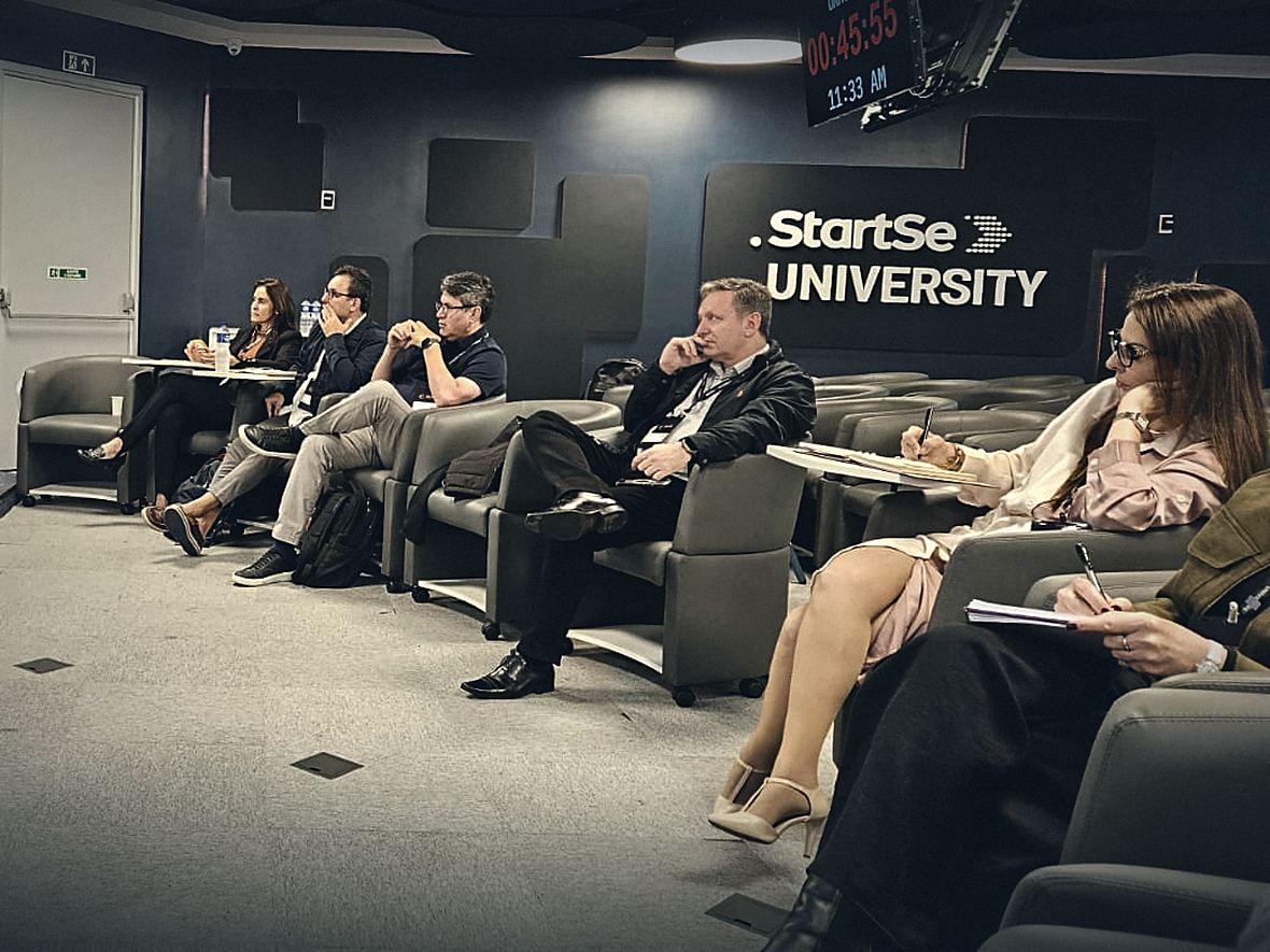Executivos sentados em uma sala de aula da StartSe University, acompanhando uma apresentação.